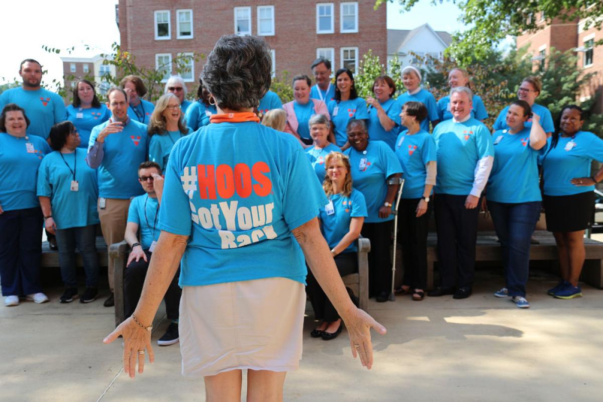 Group of UVA employees stand together with "#HOOS Got Your Back" t-shirts.
