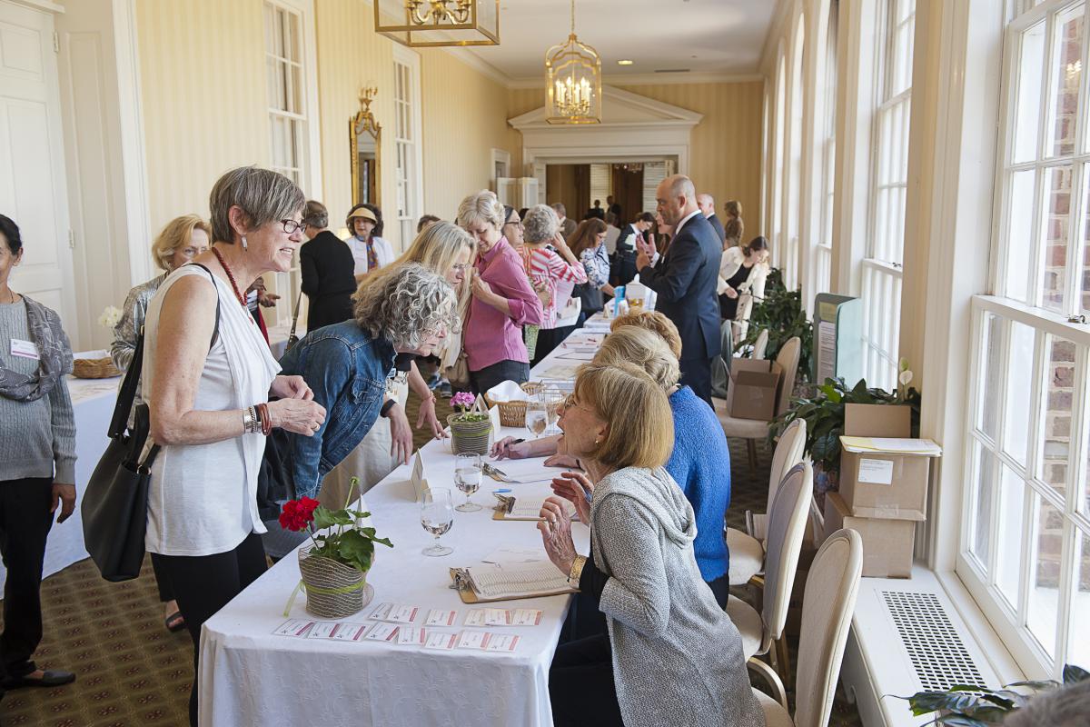 Women visit tables to check into the Women's Midlife Symposium