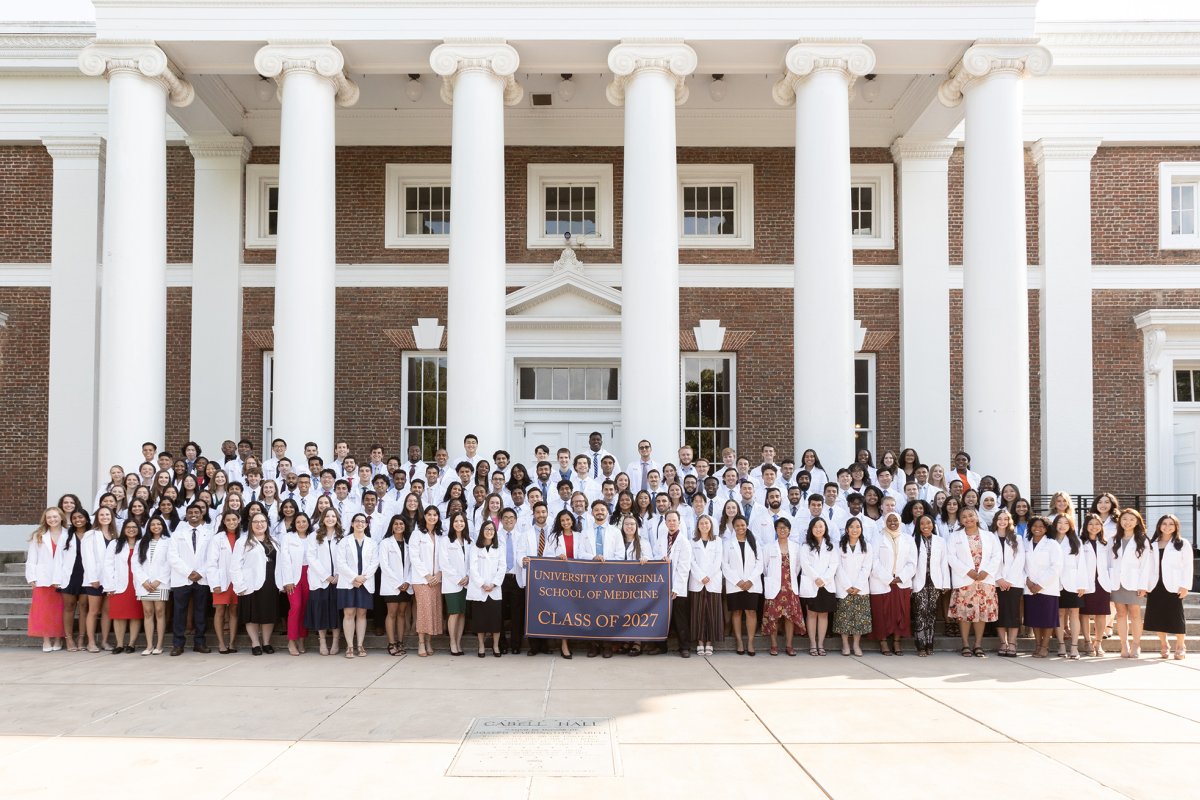Students from school of med class of 2027 stand in front of building on grounds