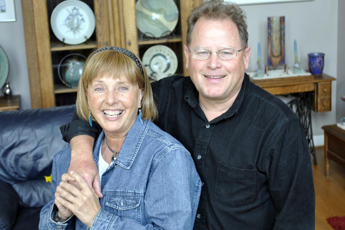 Marty Whitlow and John Whitlow sit together in their house. 