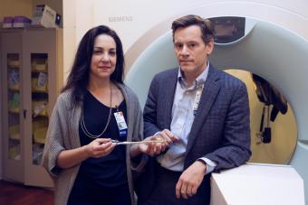 Drs. Shayna and Tim Showalter in front of an MRI machine.