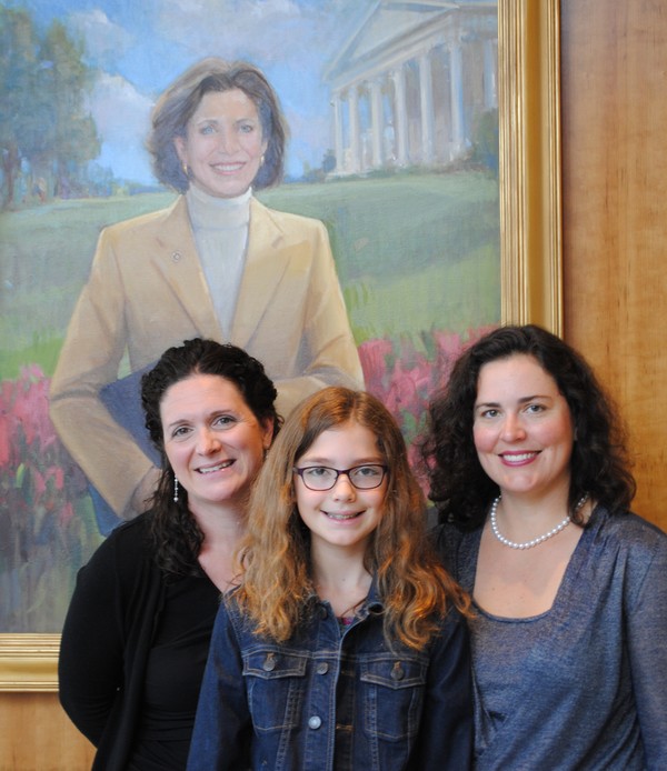Framed by a painting of Emily Couric, Jody Reyes (left) meets Emily Wadlow and Jessica Wadlow (Emily’s granddaughter and daughter-in-law) for a tour of theCouric Center.