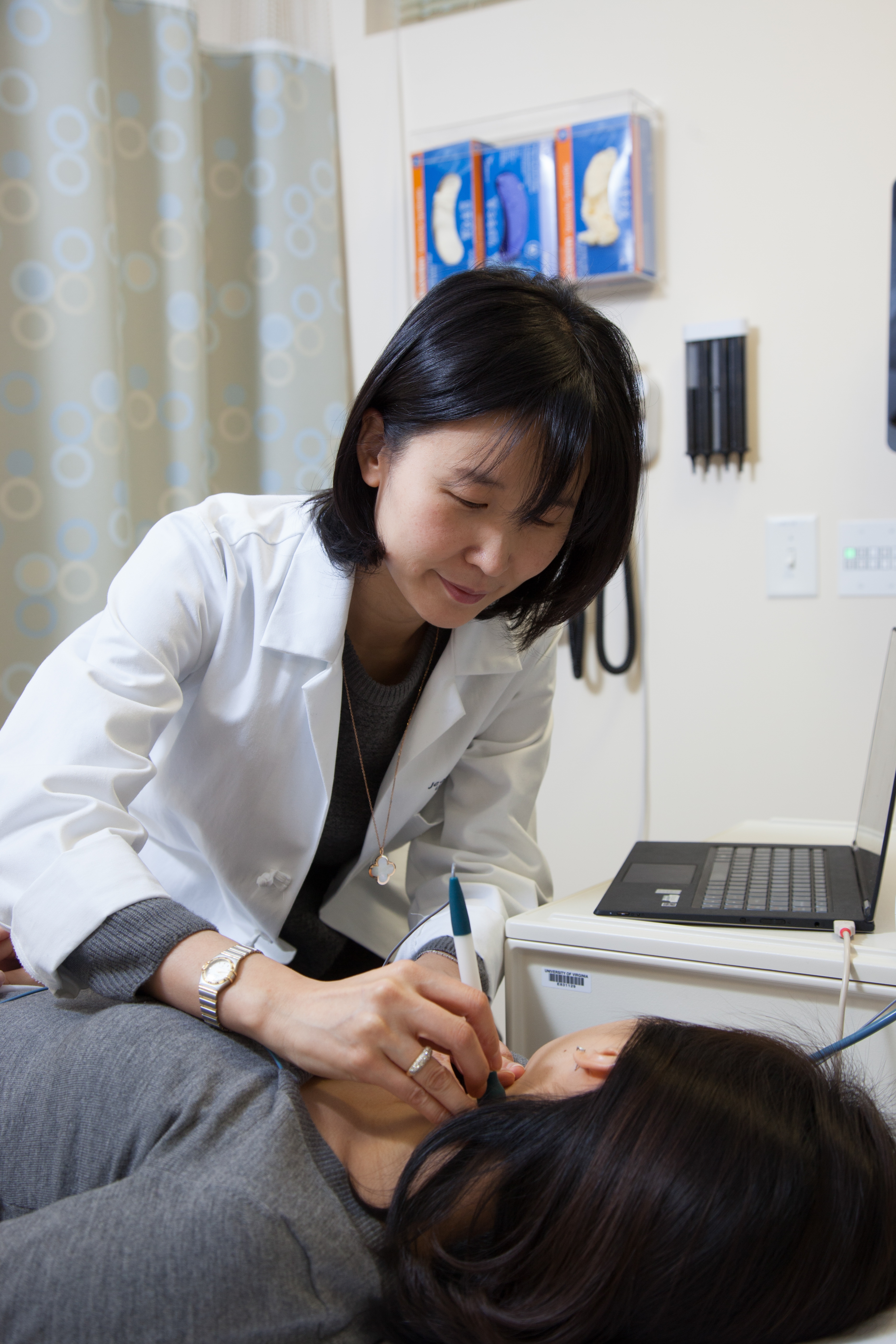 Jeongok Logan, a Roberts Scholar, takes a mesaurement on a patient in a treatment room. 