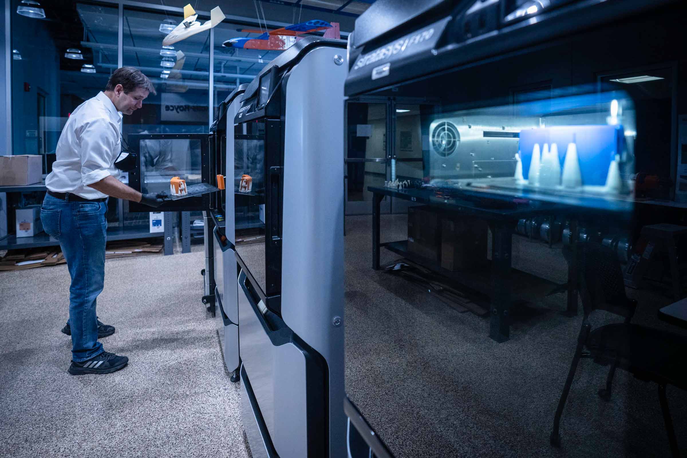 Engineering associate professor Gavin Garner checks on the masks as they are printing. 