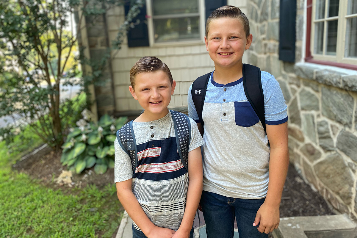 Conor and his older brother standing with backpacks on