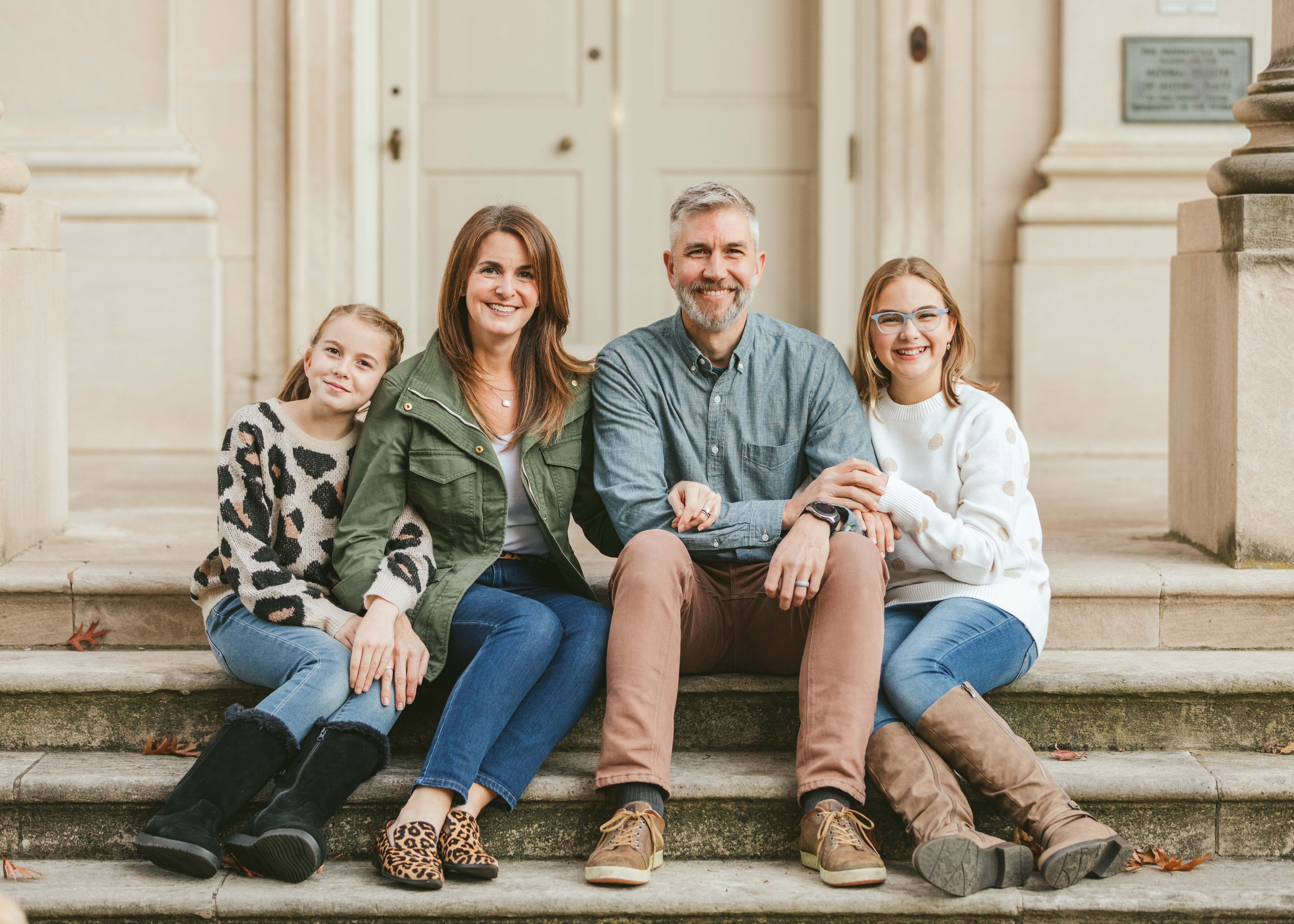 Hannah and her family sit together on a set of stairs