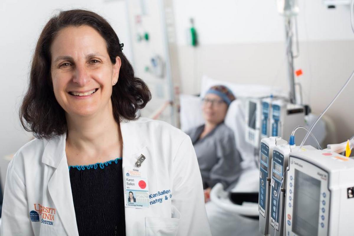 Karen Ballen stands in front of a patient 