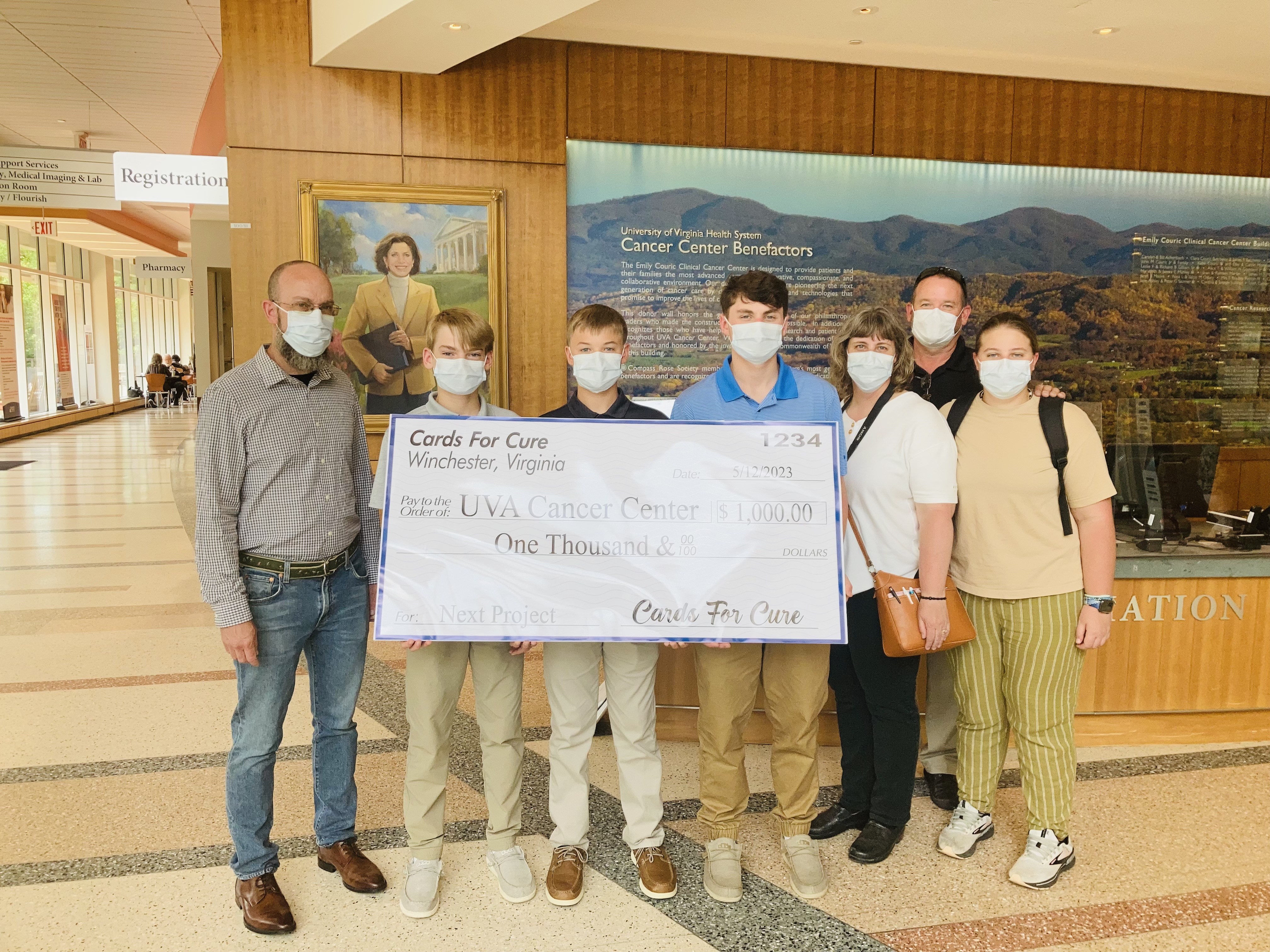 The young men and family members presented a giant commemorative check to UVA Cancer Center. 