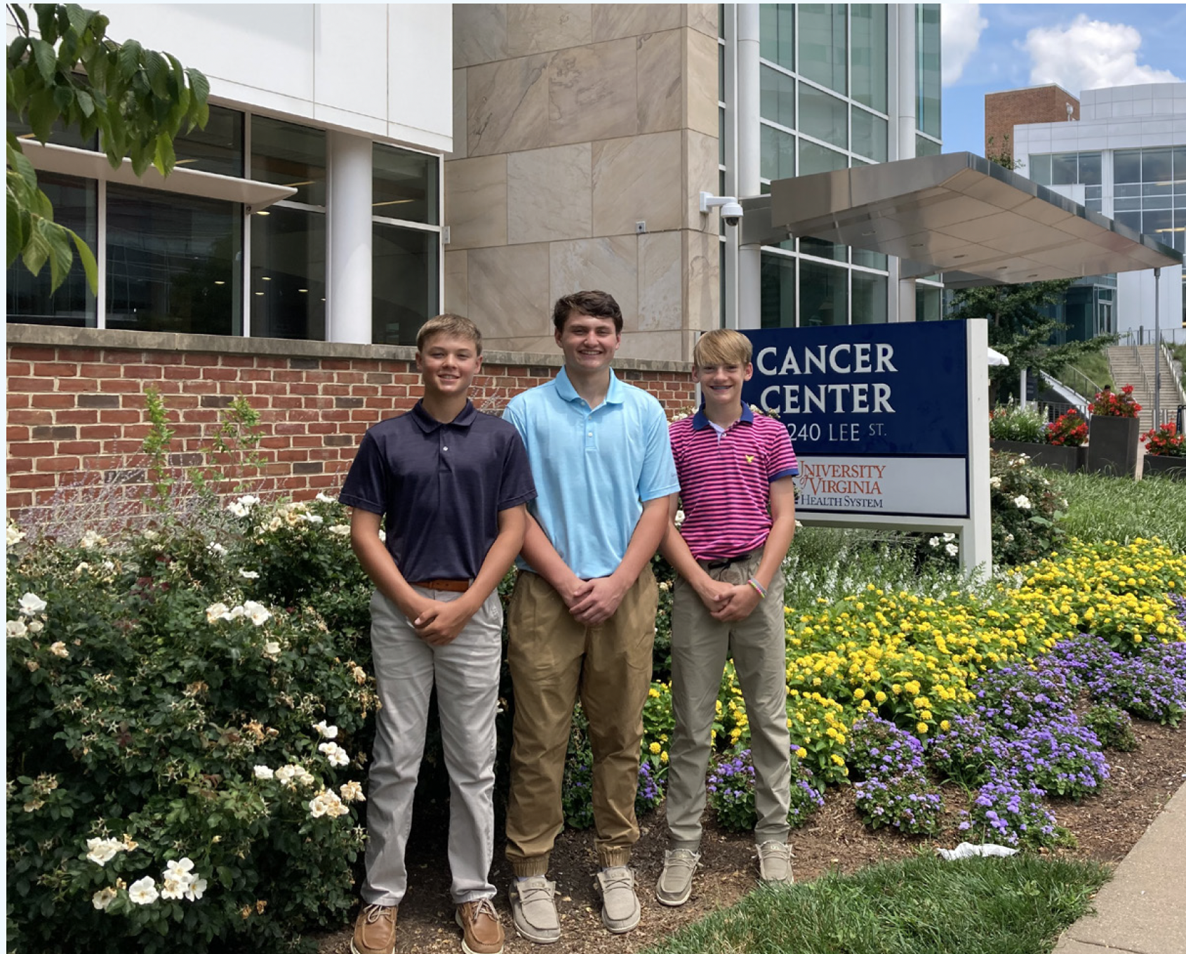 The three boys stand outside the UVA Cancer Center