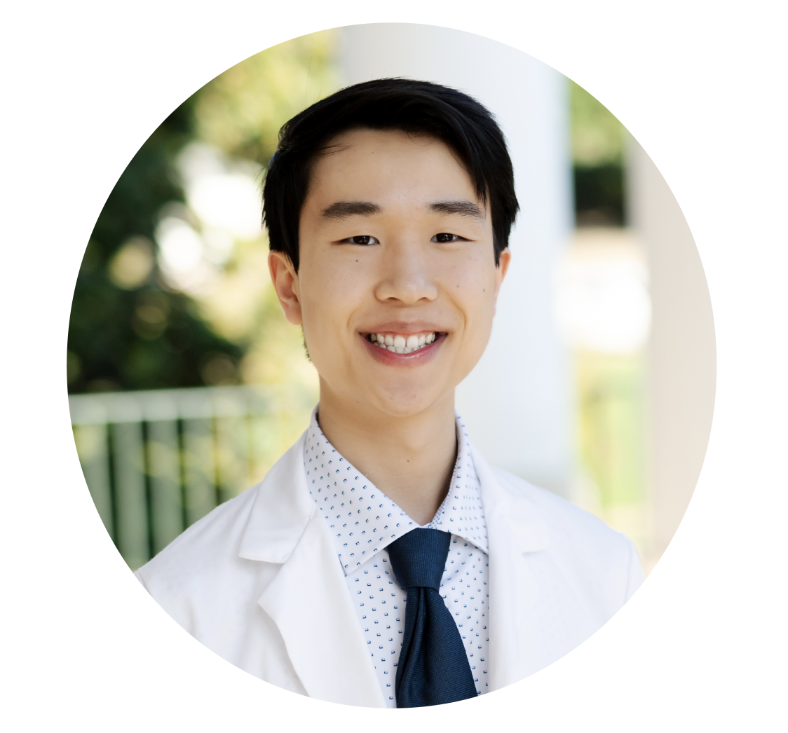 male student headshot outside in his white coat