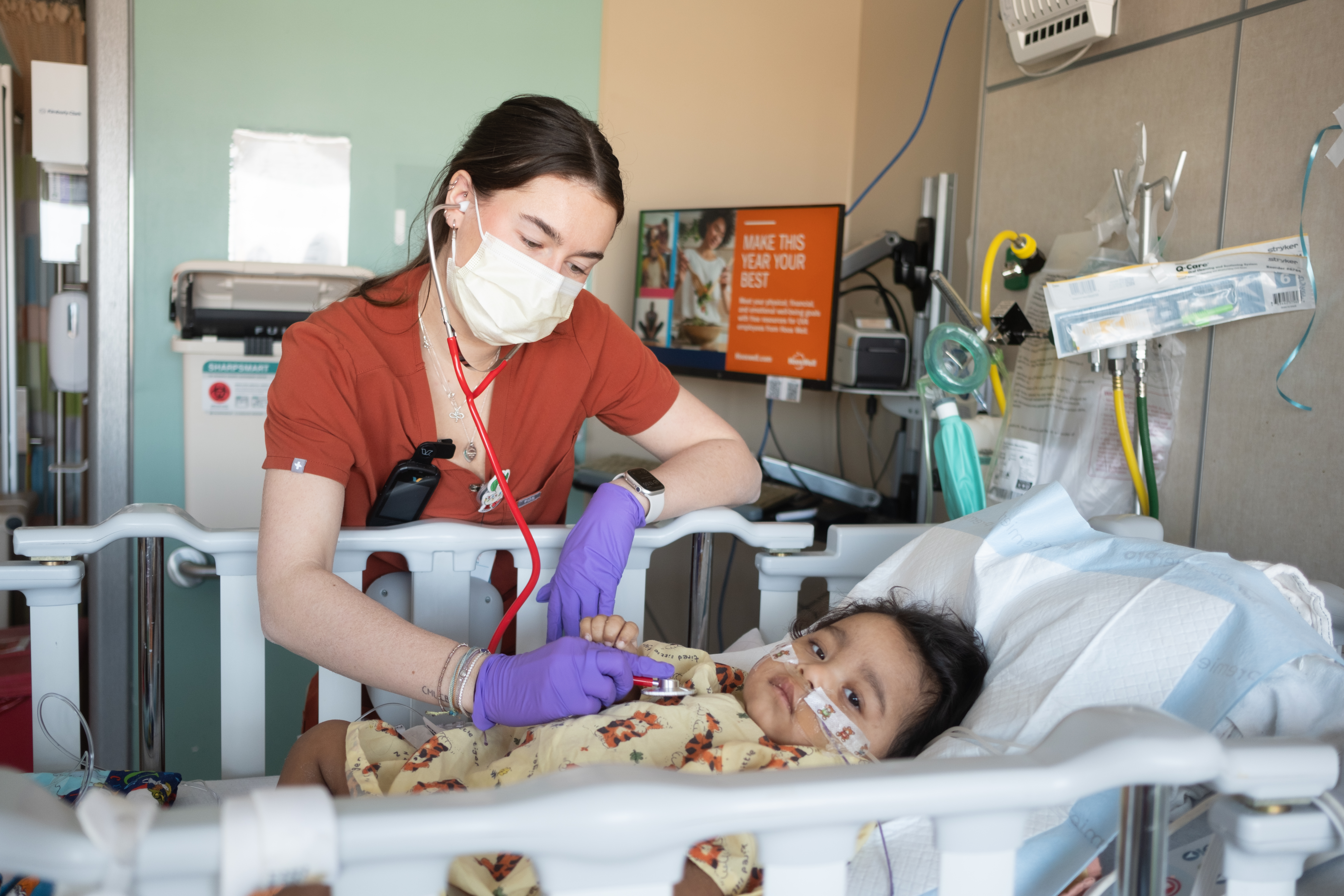 a nurse cares for a child in a hospital bed