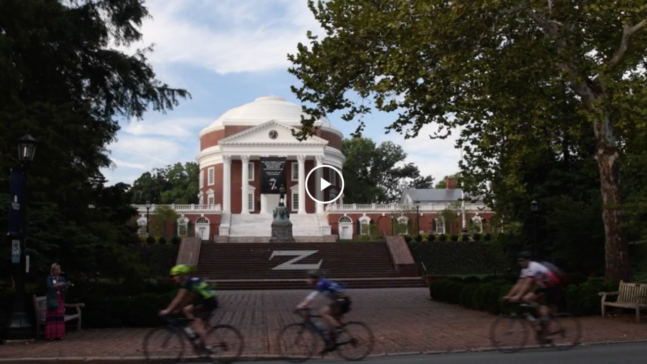 The rotunda is in the background, cyclists are seen riding by.