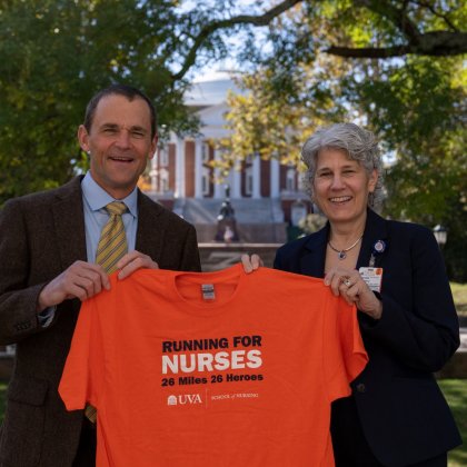 President Jim Ryan and School of Nursing Dean Pam Cipriano stand holding a shirt 