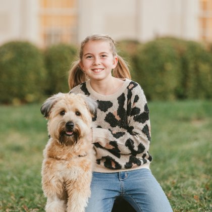 Hannah smiles with her arm around her dog