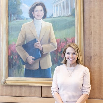 Katie stands in front of a portrait of her sister