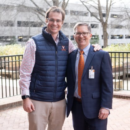 Peter Farrell stands outside with his arm around Dr. Bauer.