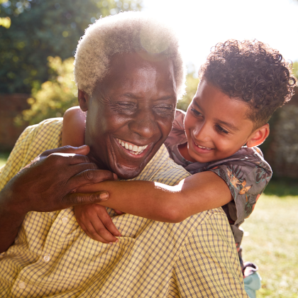 Grandfather and grandson embrace outside