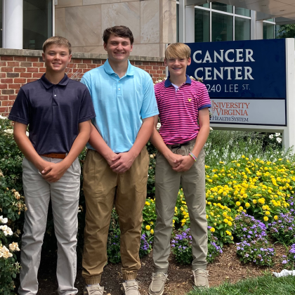 Three highschoolers stand in front of the cancer center