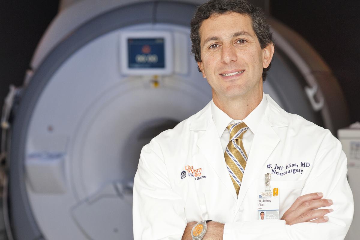 Neuro researcher Jeff Elias stands in front of a focused ultrasound machine.