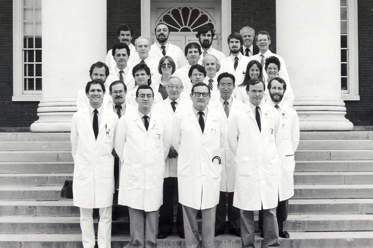 A black and white photo of the UVA Neurology team standing on the steps of the rotunda in 1985.