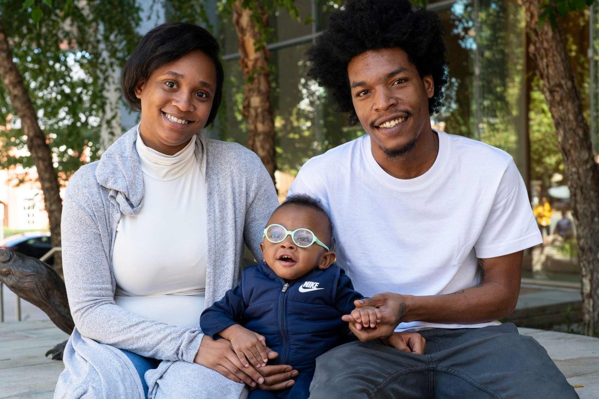 parents sit outside UVA Health Children's with their young son between them