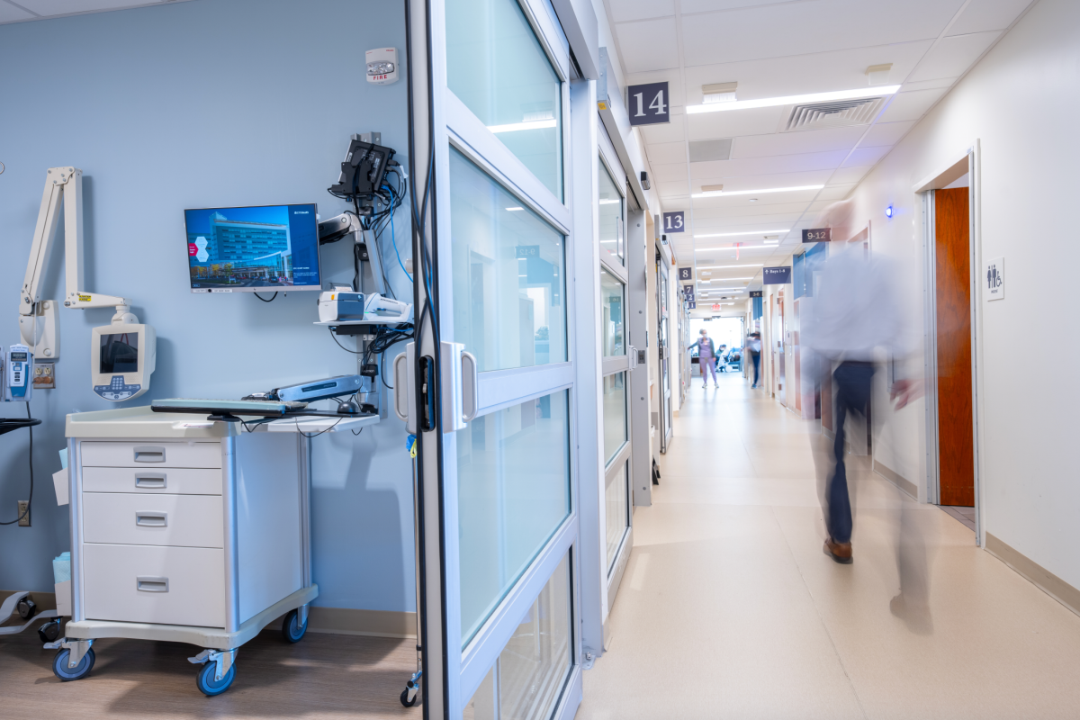 A care provider rushing down a hospital hallway