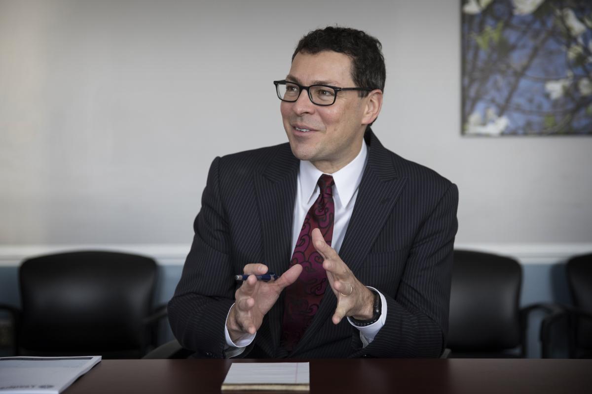 Dr. José Oberholzer sits at a desk and gestures with his hands while explaining a concept