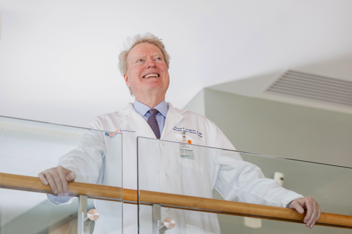 Dr Loughran stands in his white coat looking into the distance