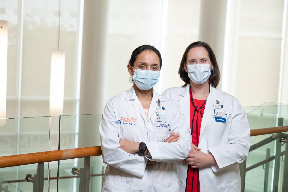 Dr. Varinder Kaur and Dr. Einsley-Marie Janowski stand in hospital wearing white coats