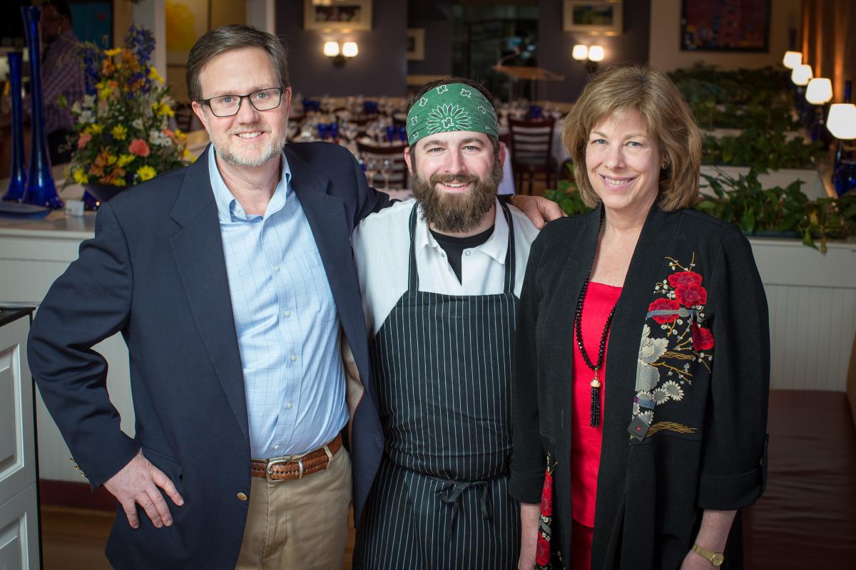 (From left to right) Bill Hamilton, Curtis Shaver, and Kate Hamilton stand beside eachother at the 20th anniversary fundraising dinner at Hamiltons’ at First & Main