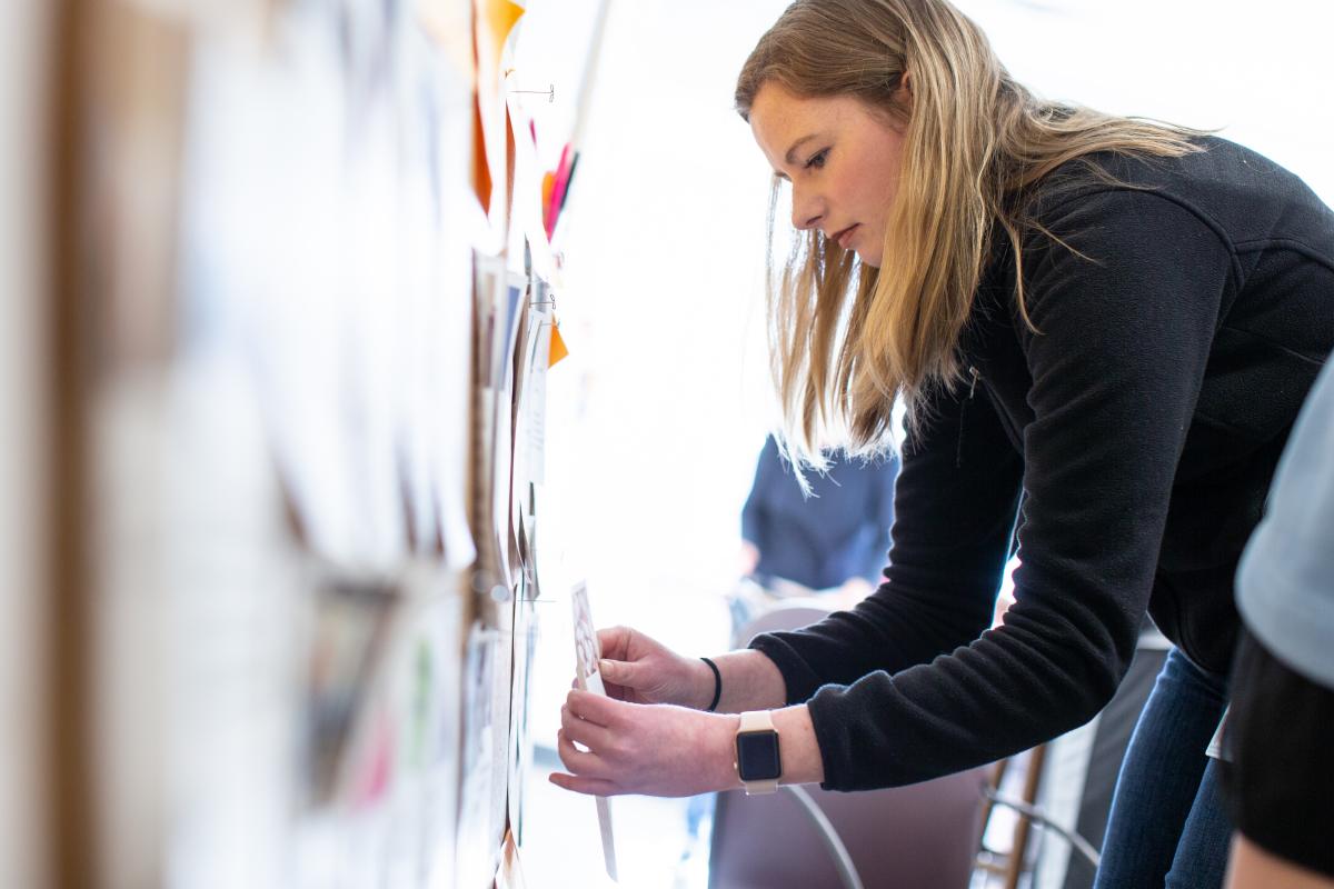 A UVA school of medicine student works at a white board.