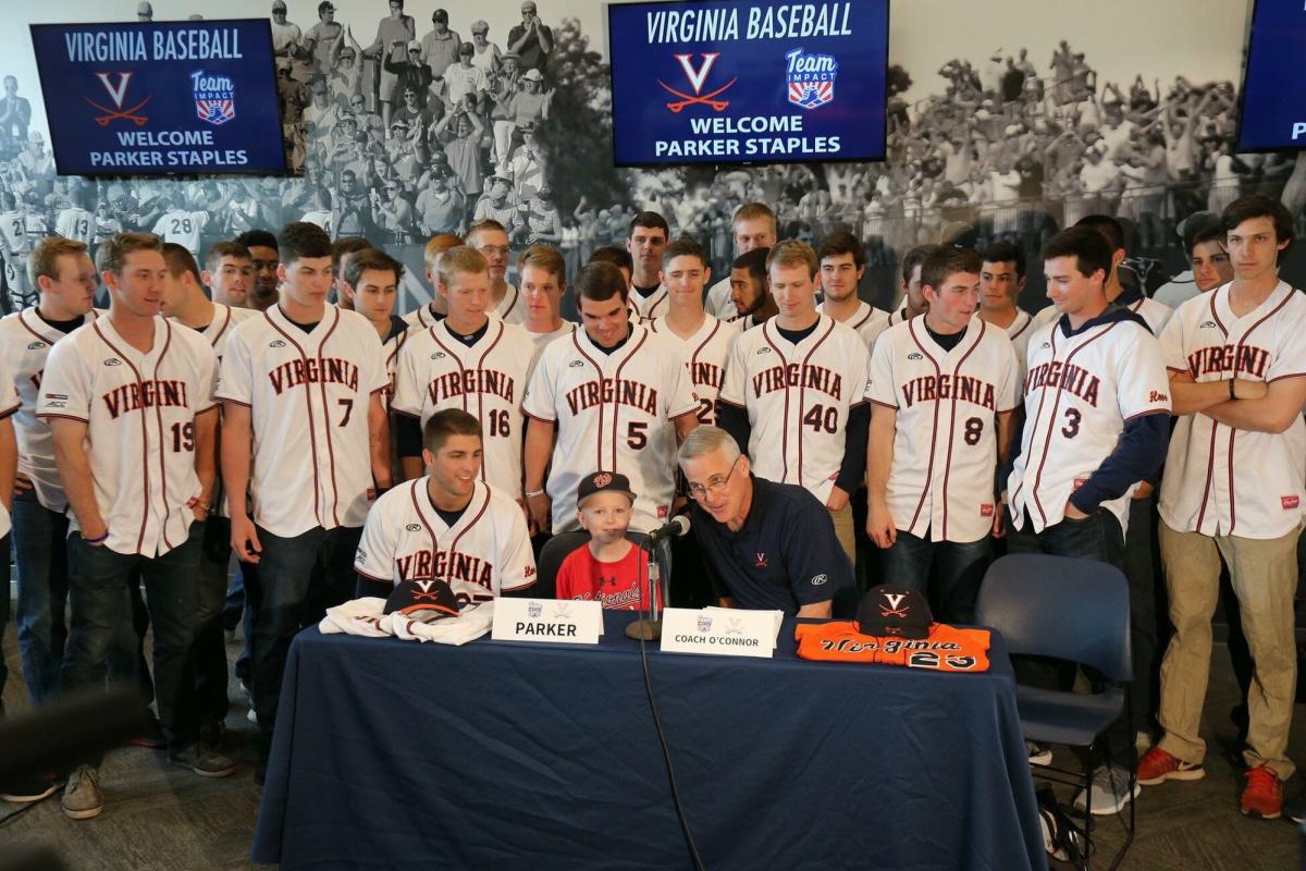 Nine-year-old Parker Staples sits with the UVA baseball team.
