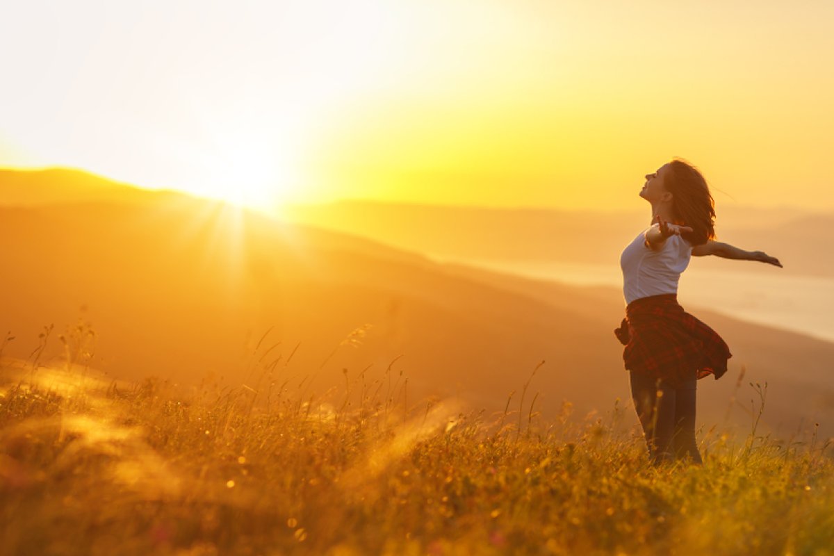 woman standing facing the sunrise