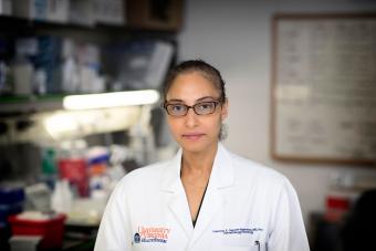 A headshot of Francine Garrett-Bakelman wearing a white coat in her lab.