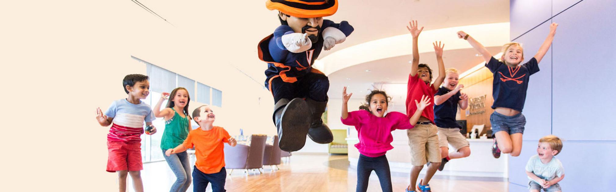Patients at UVA Health Children's hospital jump in the air with UVA mascot Cav man.